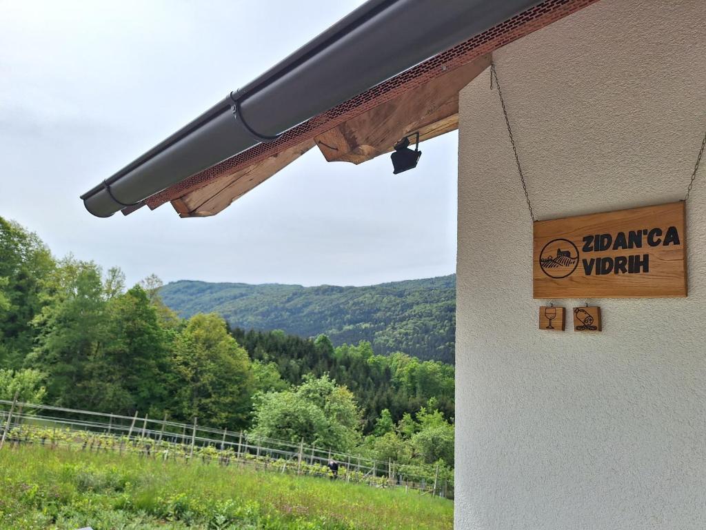 um sinal na lateral de um edifício com uma montanha em Vineyard Cottage Vidrih em Dolenjske Toplice