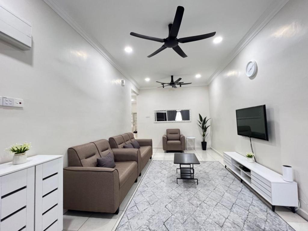 - un salon avec un canapé et un ventilateur de plafond dans l'établissement SAFRA HOMESTAY PERLIS, à Arau