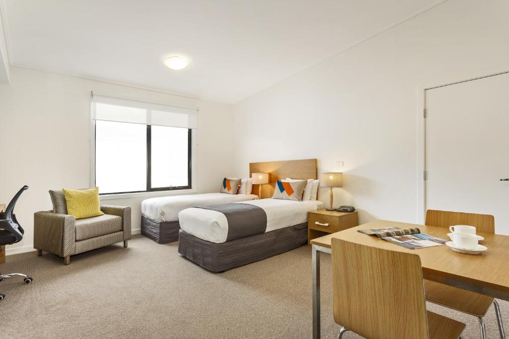 a hotel room with a bed and a desk and a chair at Quest Frankston in Frankston