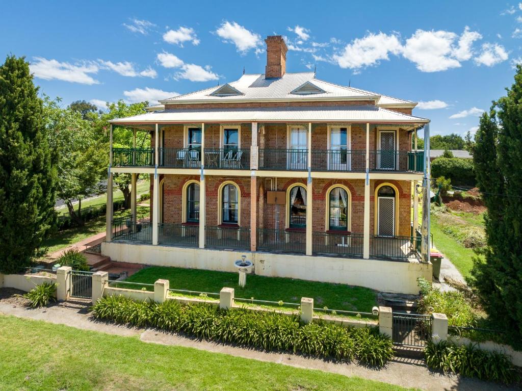 an old house with a turret on a lawn at The White House - Heritage Style Terrace in Molong