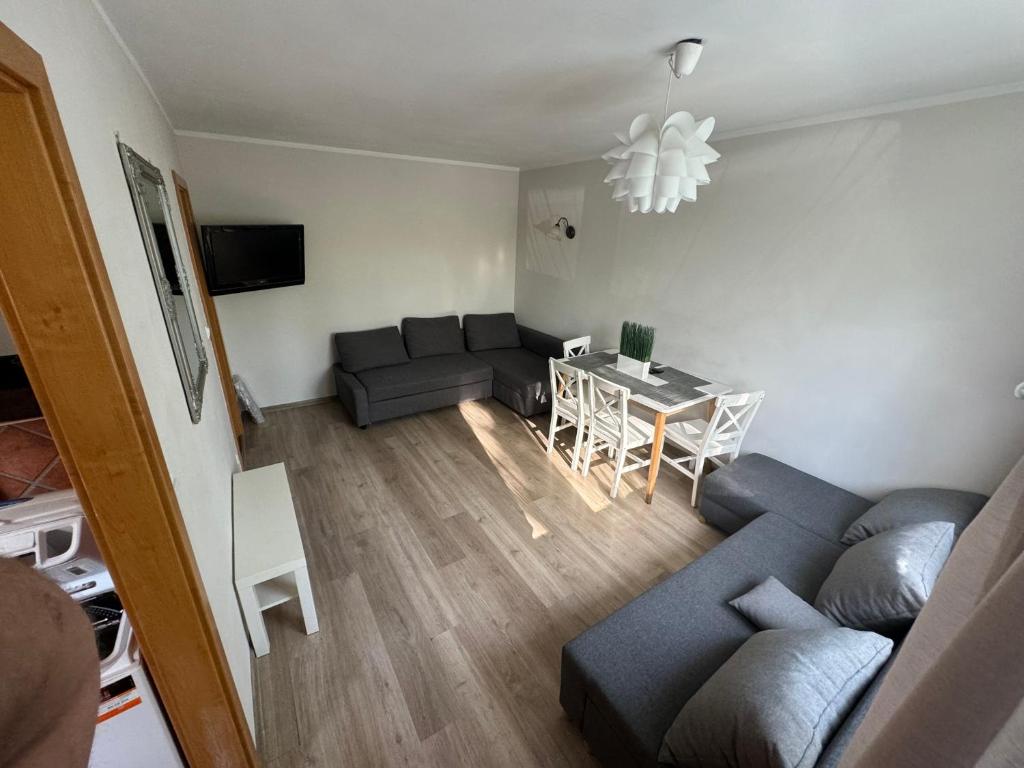 uma sala de estar com um sofá e uma mesa em Witawa 2024 em Gdynia