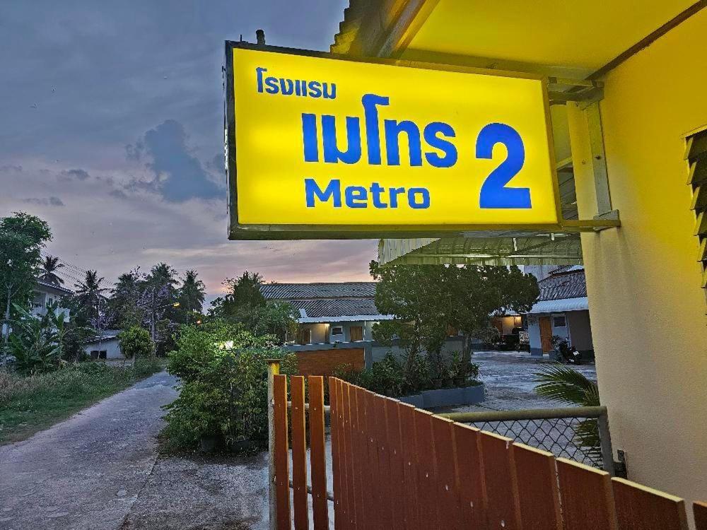 una señal amarilla en un edificio con una señal de metro latina en โรงแรมเมโทร2 Metro2, en Satun
