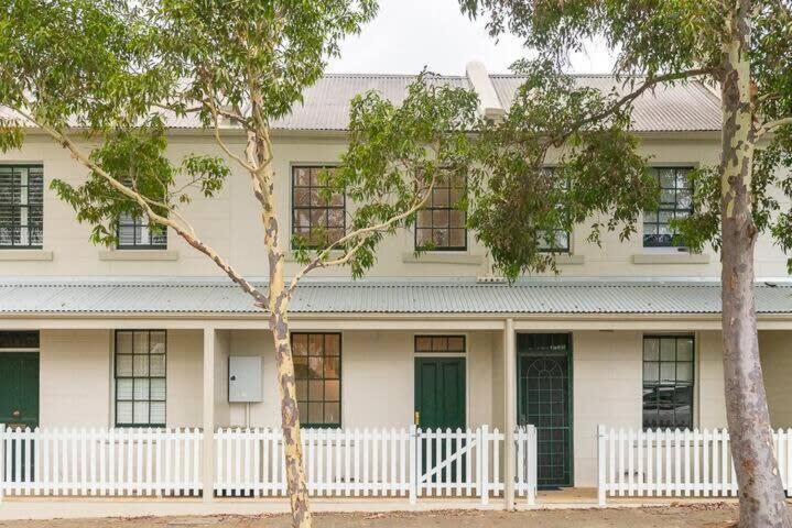 una casa bianca con una recinzione bianca e due alberi di Modern Heritage Home - Stunning Bridge Views a Sydney