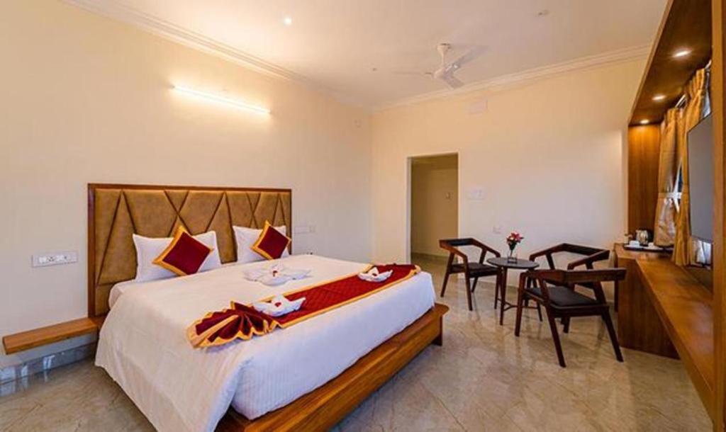 1 dormitorio con 1 cama grande y 1 mesa en FabHotel Prime AR Phalazzo Resort en Pondicherry