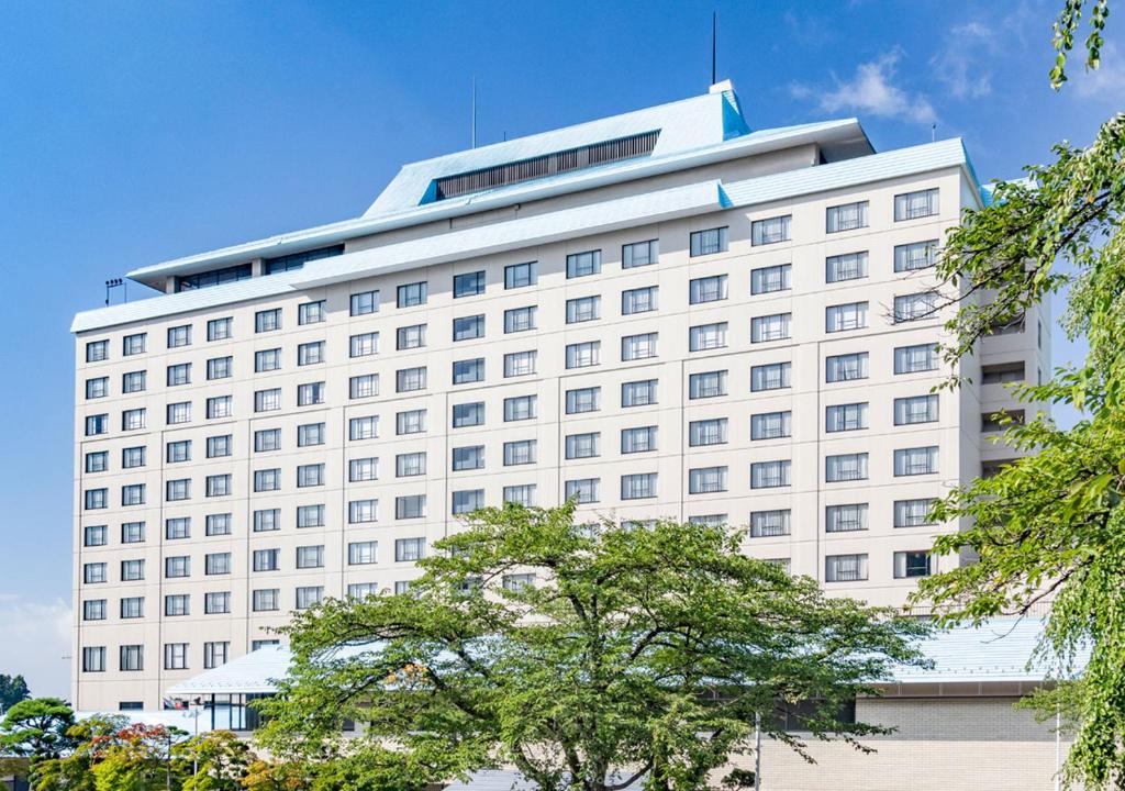 a large white building with a lot of windows at Hotel Senshukaku in Hanamaki