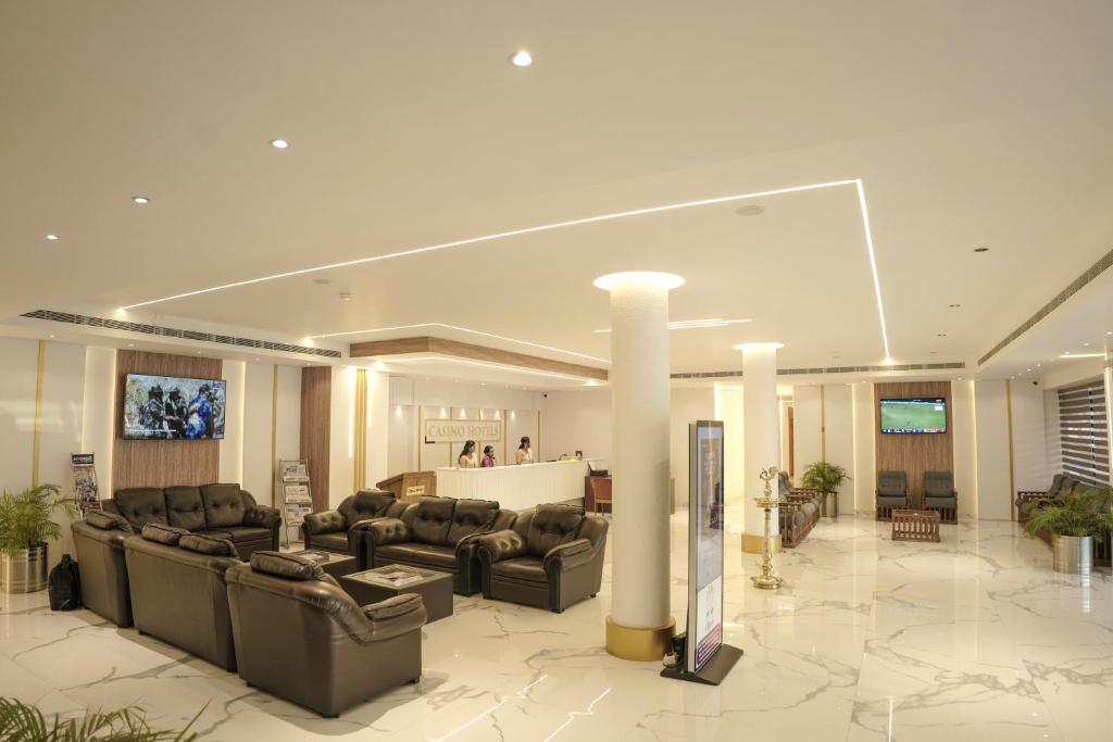 a living room with couches and chairs in a lobby at Casino Hotels Ltd in Trichūr