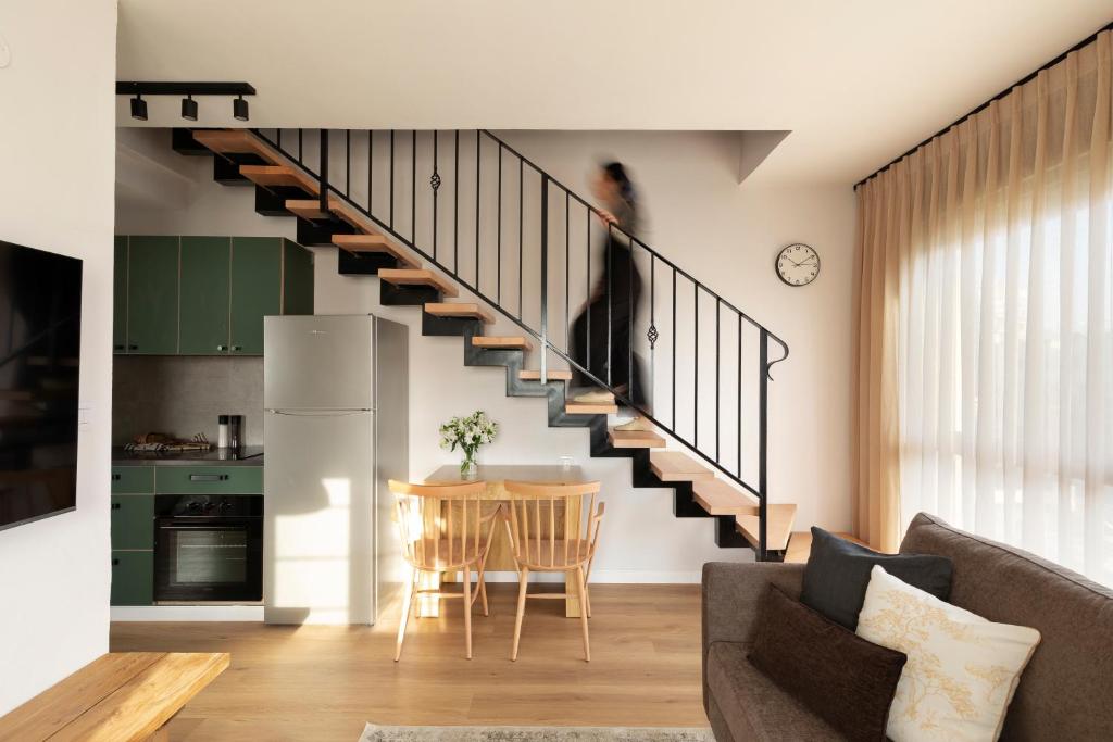 a living room with a staircase leading to a kitchen at AirTLV - Arlozorov Apartment's in Tel Aviv