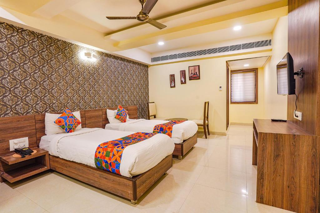 pokój hotelowy z 2 łóżkami i telewizorem w obiekcie FabHotel Ginger Suites w mieście Bengaluru