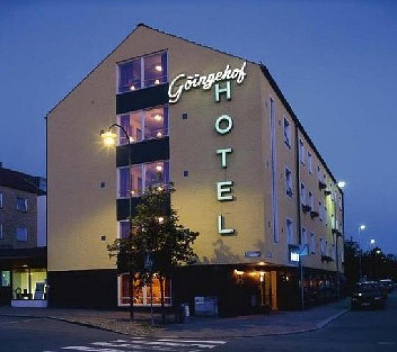 un gran edificio con un cartel en el costado en Hotel Göingehof, en Hässleholm