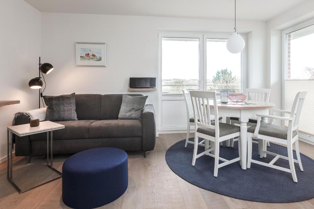a living room with a couch and a table and chairs at Luv in Juist