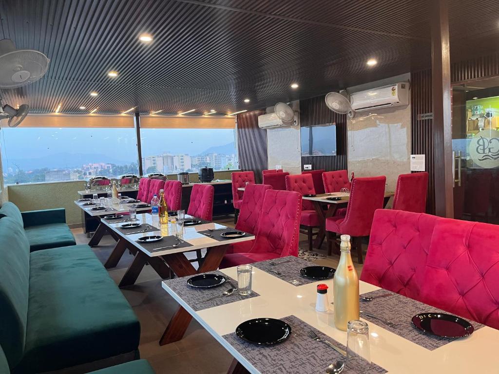 ein Esszimmer mit Tischen und roten Stühlen in der Unterkunft Hamshu Cafe & Stay in Kota