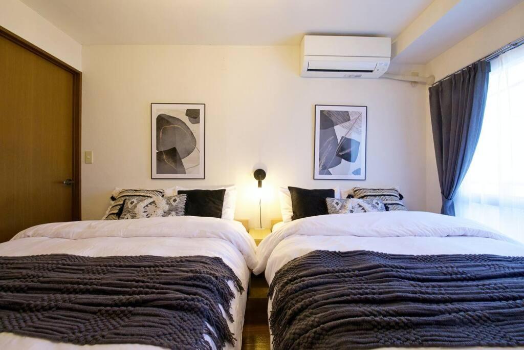 a bedroom with two beds and a lamp in it at NHビル 4F in Tokyo