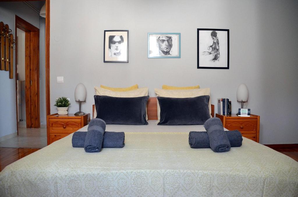 una camera da letto con un grande letto con cuscini blu di Family and Relaxing House in a Village a Rodotópion