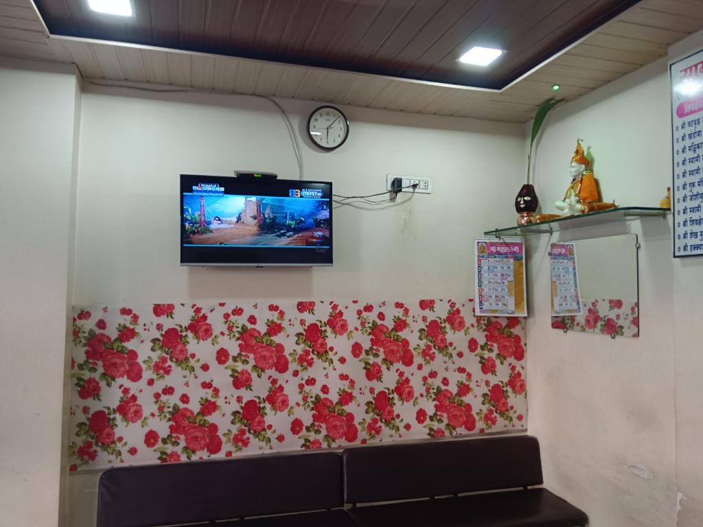 a tv on a wall with flowers on it at Samraj Lodge in Akalkot