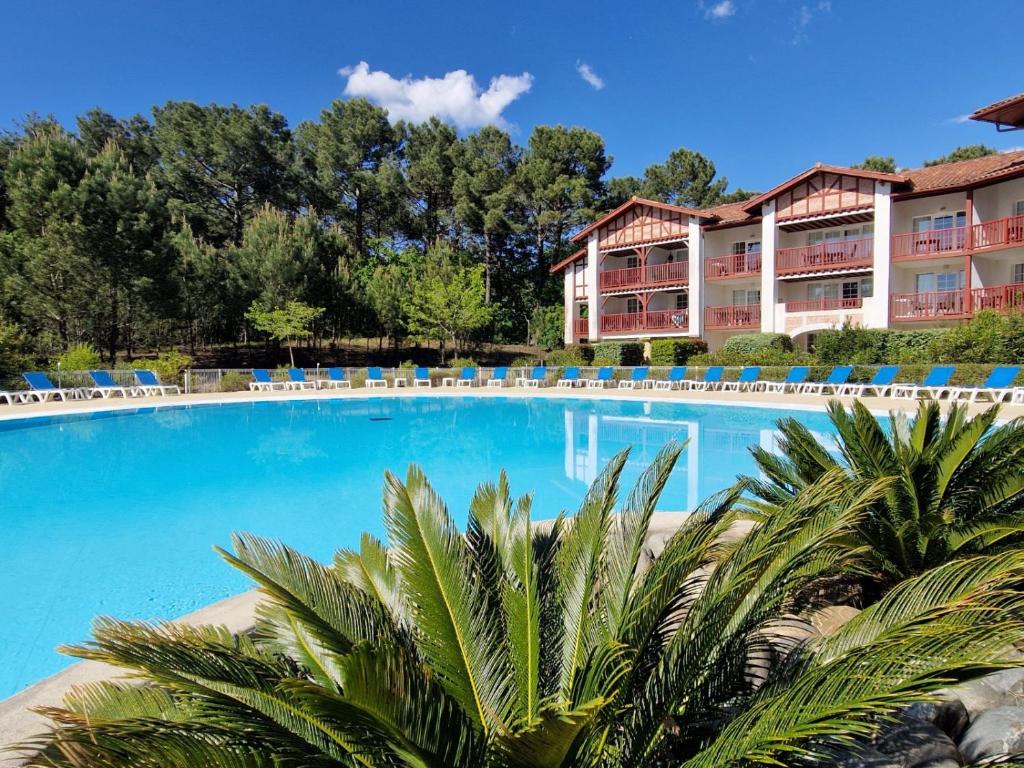 a swimming pool in front of a resort at Appartements au coeur du golf, proche du lac et vélodyssée in Biscarrosse