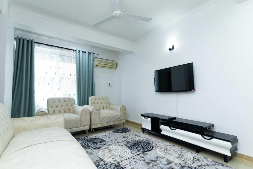 salon z 2 kanapami i telewizorem z płaskim ekranem w obiekcie Kay's Place w mieście Dar es Salaam