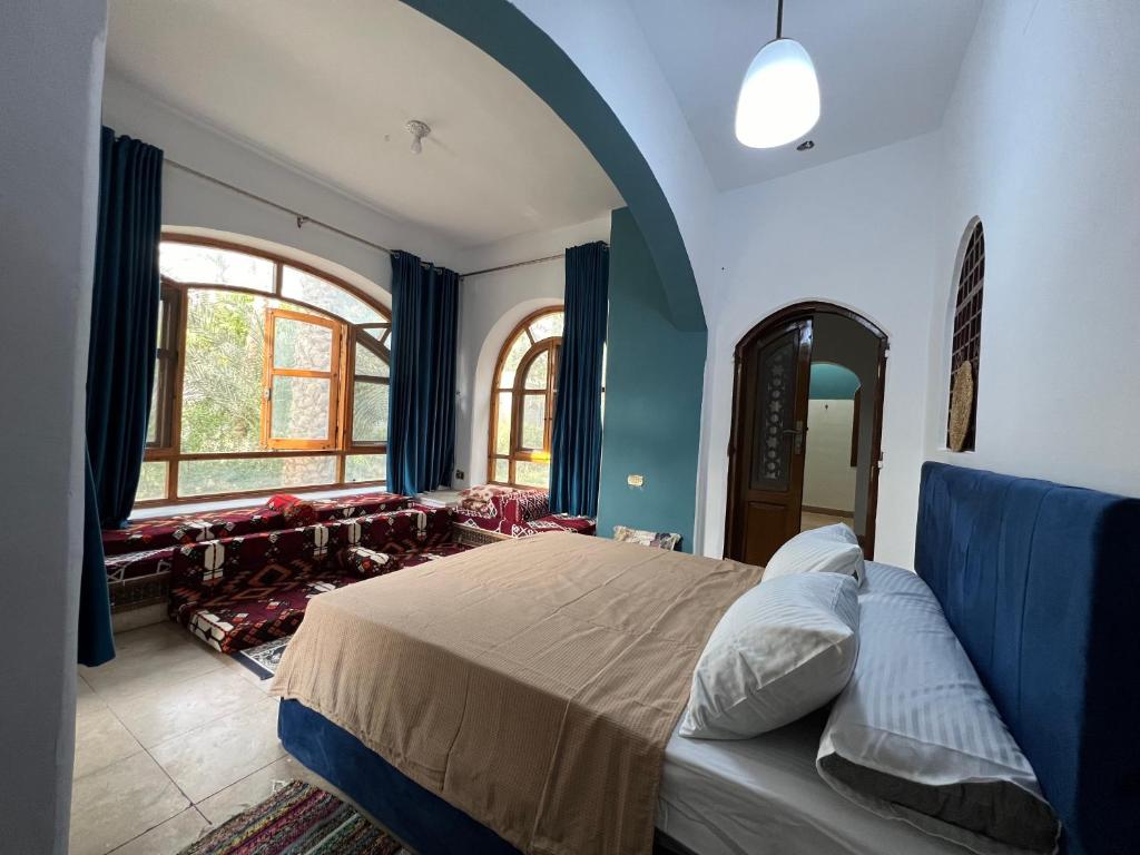 a bedroom with a bed and a large window at pyramids view Guest villa in Al Mazghūnah