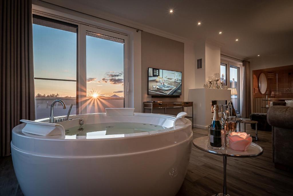 a large bath tub in a room with a large window at Luxus Spa Penthouse Royal in Göhren-Lebbin