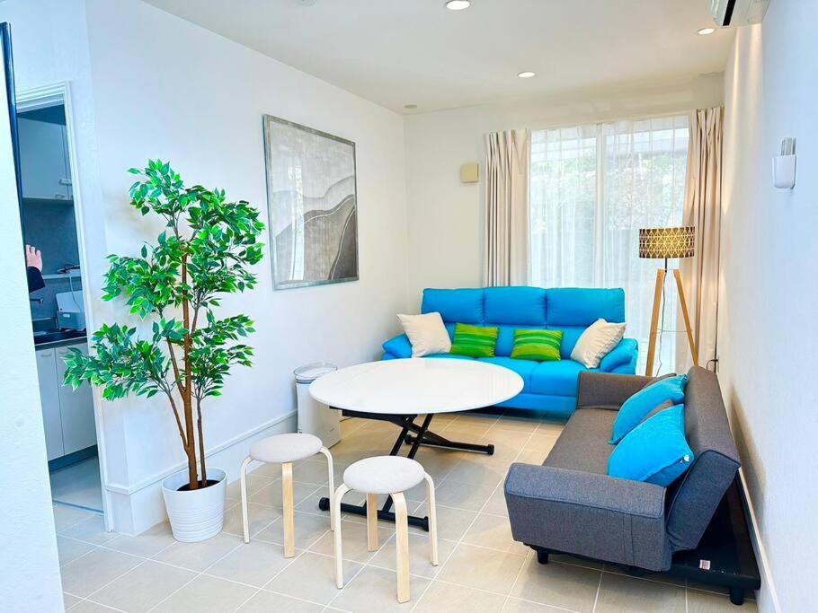 ein Wohnzimmer mit einem blauen Sofa und einem Tisch in der Unterkunft Nexus Ishinomakiokaidou in Ishinomaki