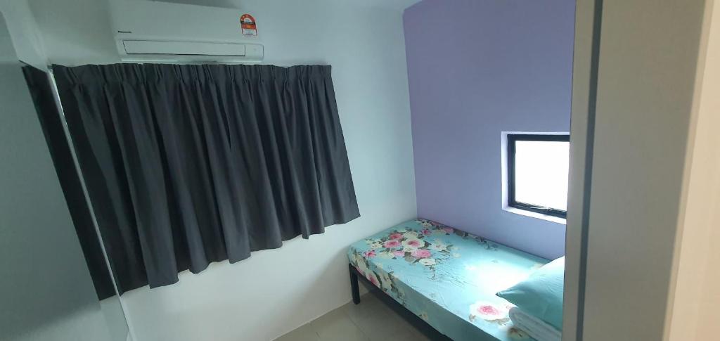 a small room with a bed and a window at Sirami homestay in Kampar