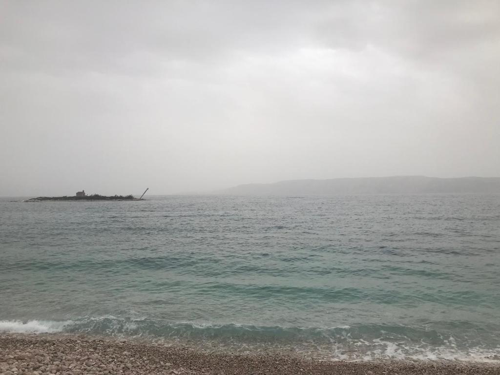 an island in the ocean with a ship in the distance at Anako in Novi Vinodolski