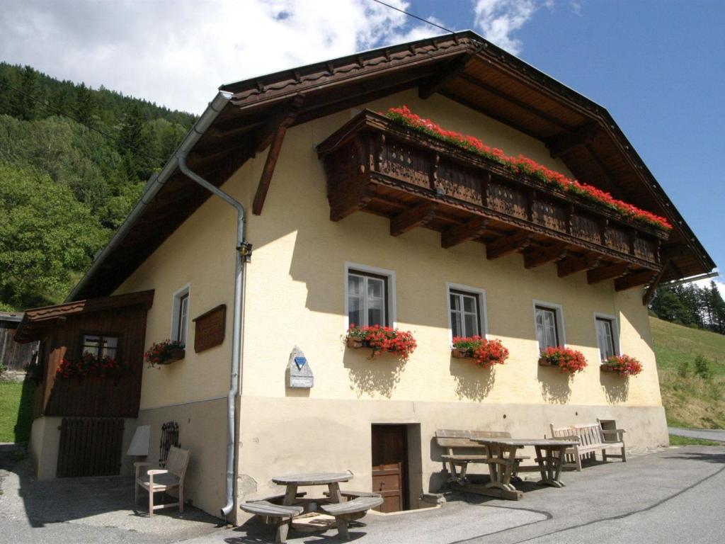 オーバーフェラッハにあるHoliday home in Obervellach near ski areaのピクニックテーブルとバルコニー付きの建物