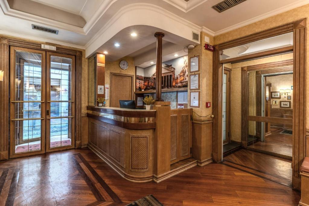 Hotel Pomezia في روما: يوجد بار في غرفة مع جدران خشبية وأرضيات خشبية
