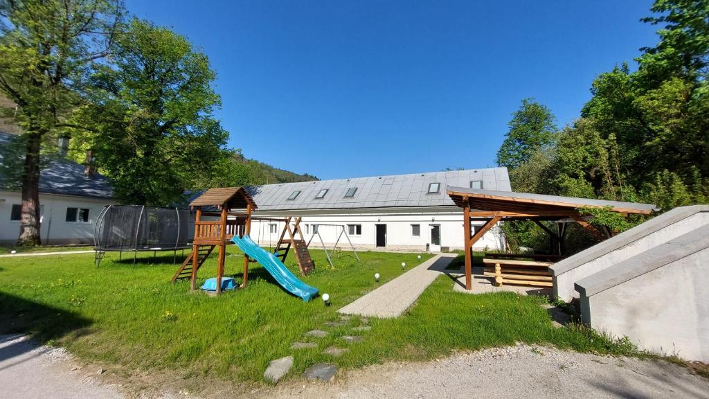 a yard with a playground with a slide at Amálkin Dvor in Podbrezová