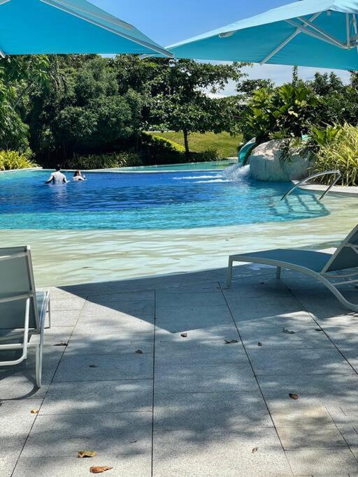 a swimming pool with two people in the water at Ma Roberta - Tambuli Resort with fast Wifi 16 Floor Studio Type in Lapu Lapu City