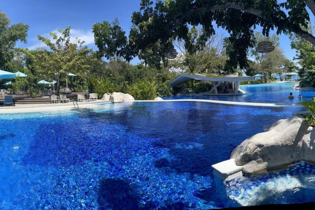 a swimming pool filled with blue water at Ma Roberta - Tambuli Resort with fast Wifi 16 Floor Studio Type in Lapu Lapu City