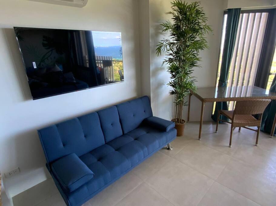 a blue couch in a living room with a table at Ma Roberta - Tambuli Resort with fast Wifi 16 Floor Studio Type in Lapu Lapu City