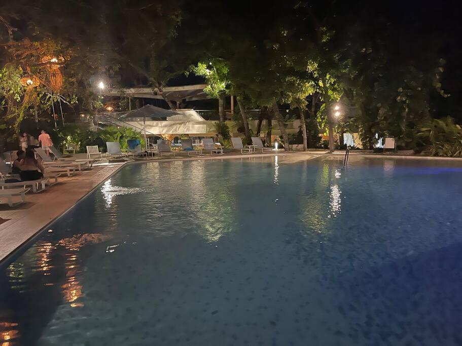 a swimming pool at night with people sitting around it at Ma Roberta - Tambuli Resort with fast Wifi 16 Floor Studio Type in Lapu Lapu City