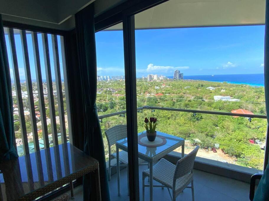 a table and chairs in a room with a view of the ocean at Ma Roberta - Tambuli Resort with fast Wifi 16 Floor Studio Type in Lapu Lapu City