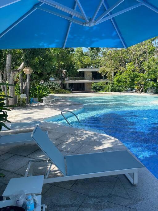 a blue umbrella sitting next to a swimming pool at Ma Roberta - Tambuli Resort with fast Wifi 16 Floor Studio Type in Lapu Lapu City