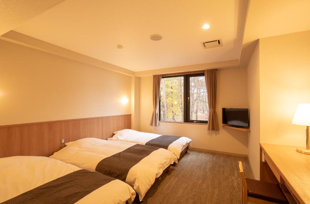 Postel nebo postele na pokoji v ubytování Motosu Phoenix Hotel