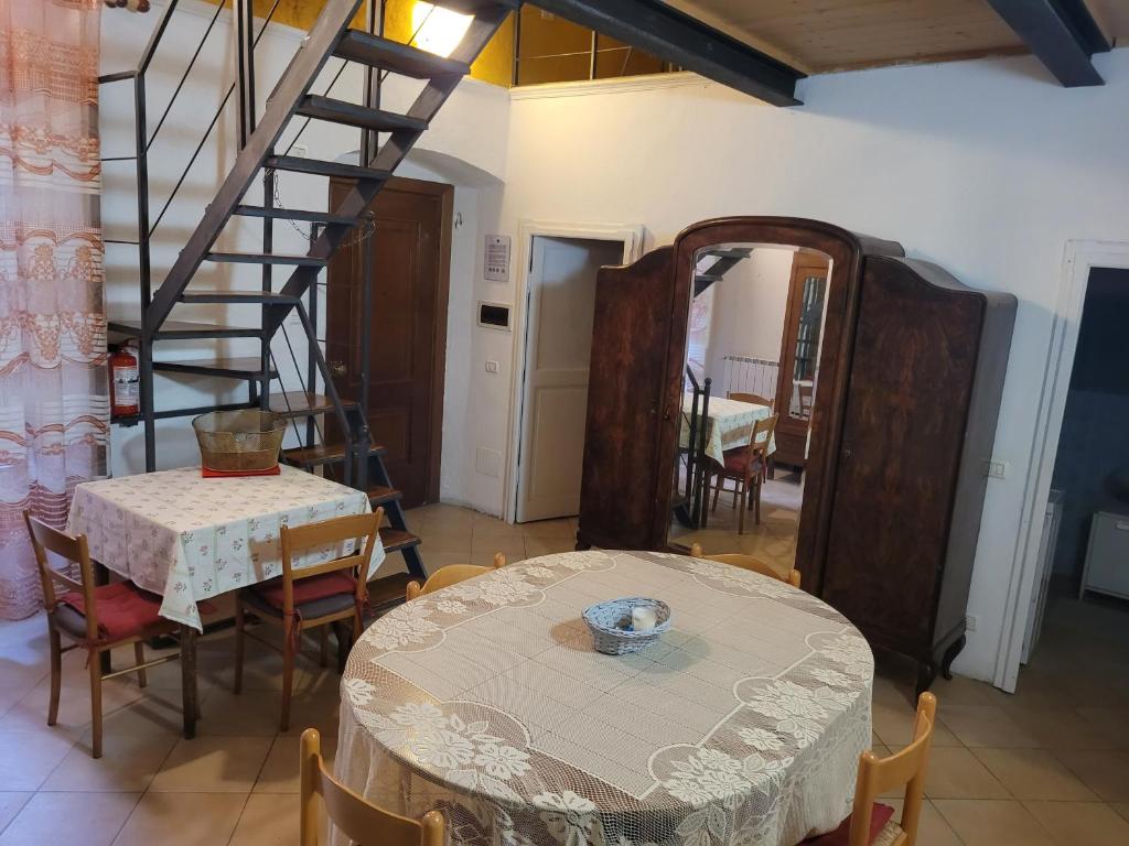 una sala da pranzo con tavolo e scala a chiocciola di Appartamento vacanze mare Loano a Loano