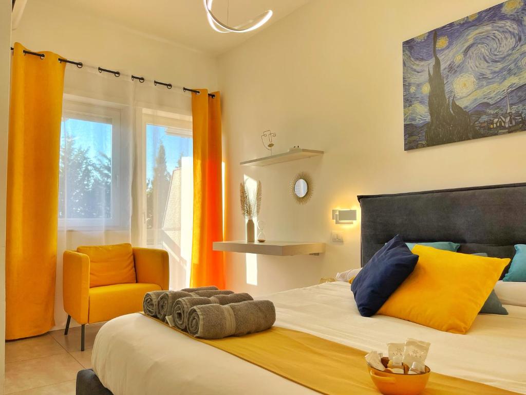 a bedroom with a large bed and a yellow chair at Modern apartment 10 min to Vaticans Museums with parking & garden in Rome