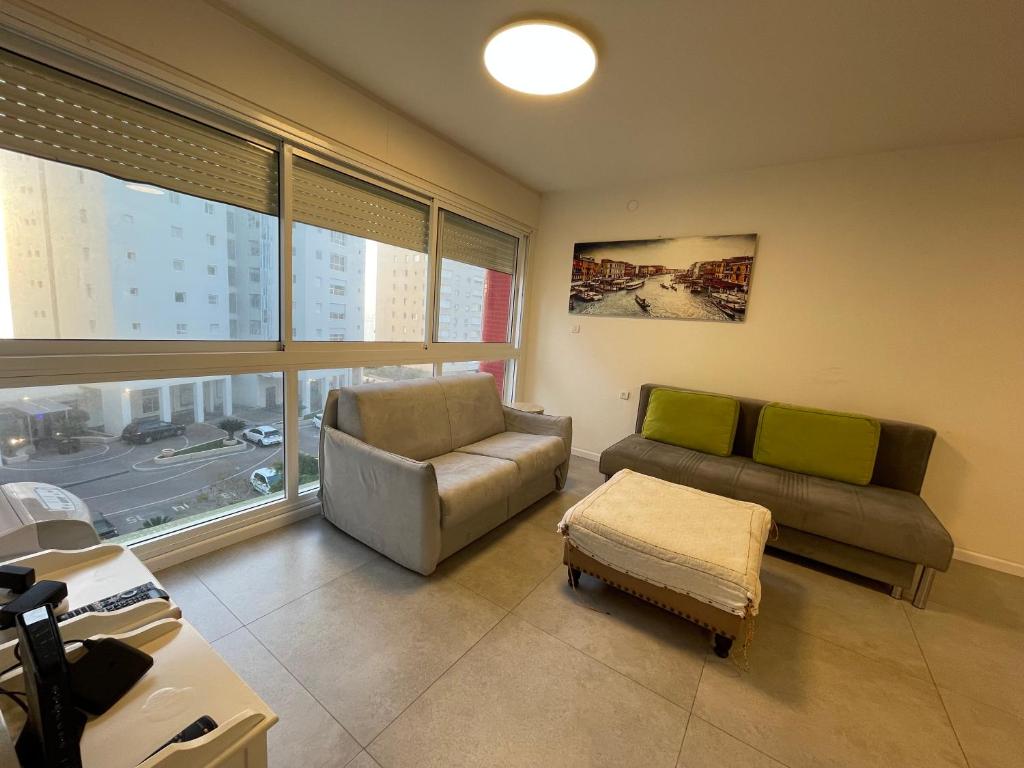 een woonkamer met een bank en een stoel bij SVW Apartment on the Beach in Netanya