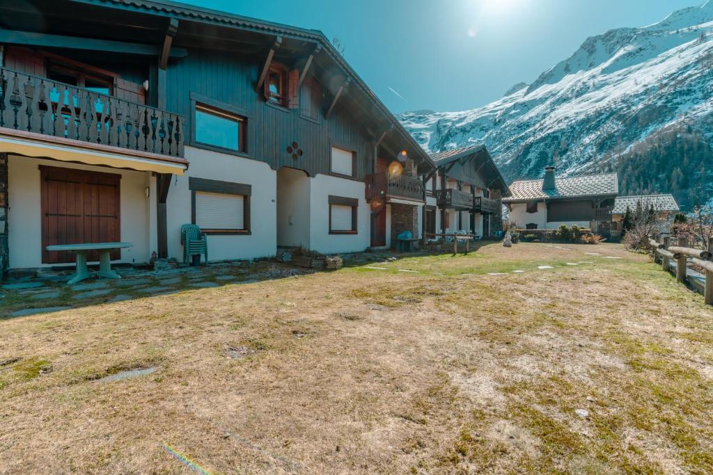 a house with a large yard in front of a mountain at 3 chambres - Plan des Reines - Happy Rentals in Chamonix