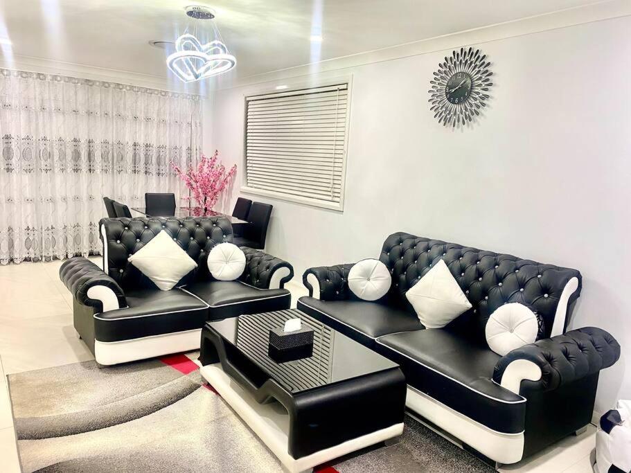 アーミデールにあるHouse on New England Hwyのリビングルーム(黒い革張りのソファ、テーブル付)