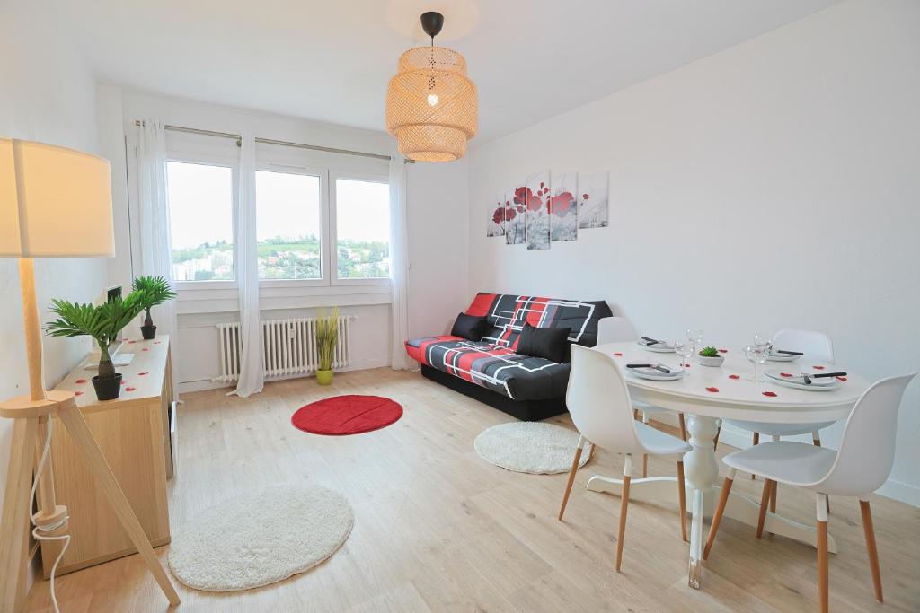 a living room with a table and a couch at Évasion Pro & Fun à Saint-Étienne - Proche HPL in Saint-Étienne