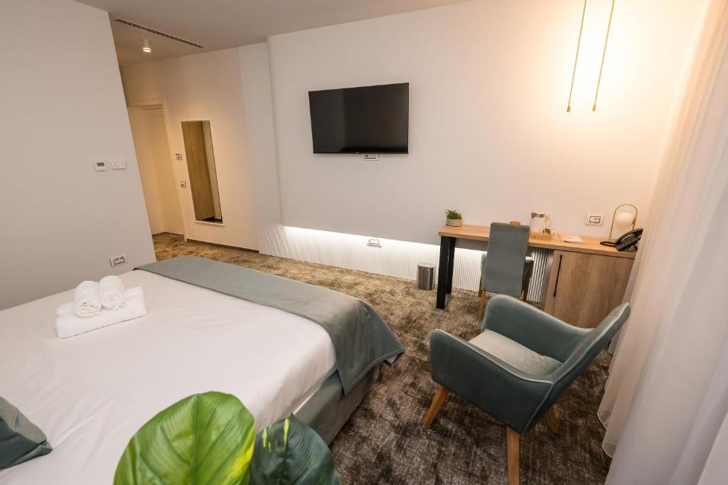 um quarto de hotel com uma cama, uma secretária e uma cadeira em ALIVE HOTEL em Oradea