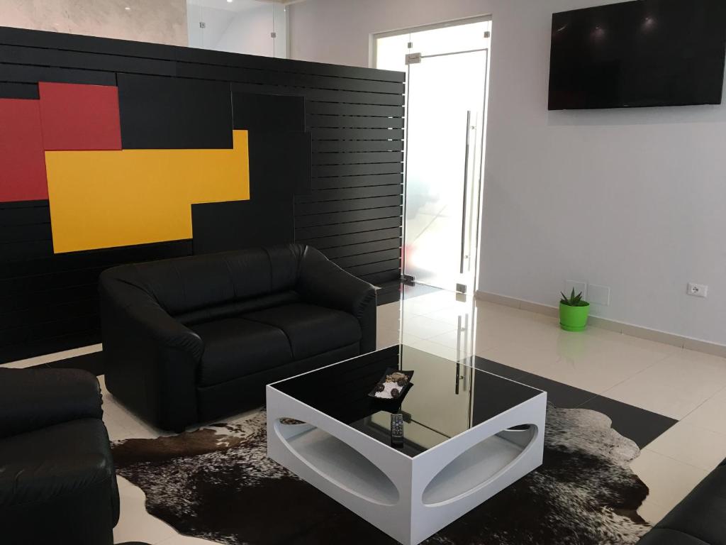 ein Wohnzimmer mit einem Sofa und einem Glastisch in der Unterkunft Hotel Ascua in Tirana
