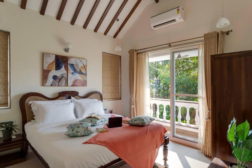 a bedroom with a bed and a large window at Villa Hestia-3bed villa in Assagao By Masaya Stays in Verla