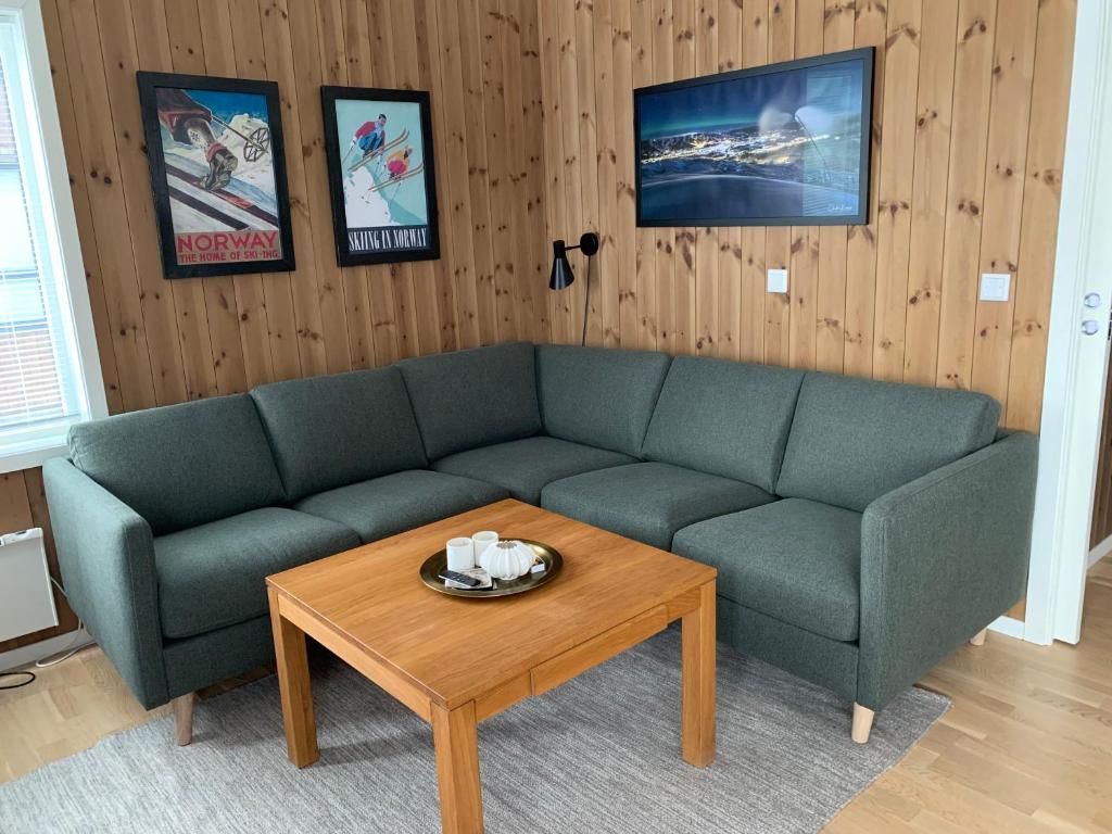 uma sala de estar com um sofá e uma mesa de centro em Slåttastølen leiligheter - by Geilolia em Geilo