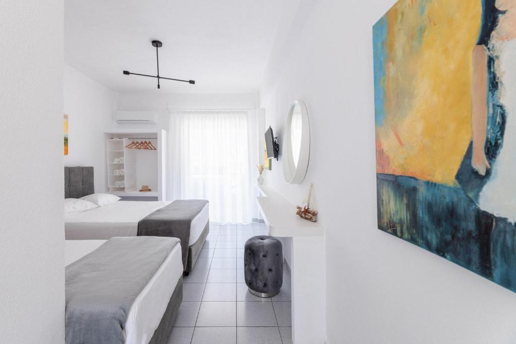 a bedroom with two beds and a painting on the wall at Valasi Studios in Skála Foúrkas