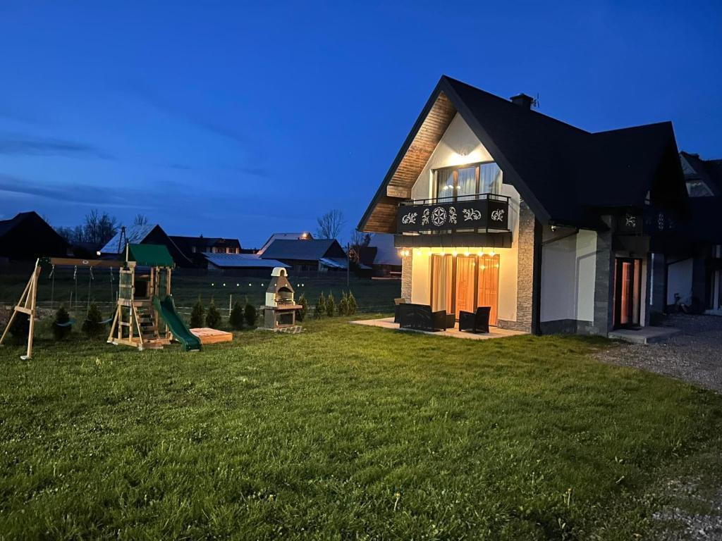 a house with a playground in the yard at FAMILY HAUSE in Witów