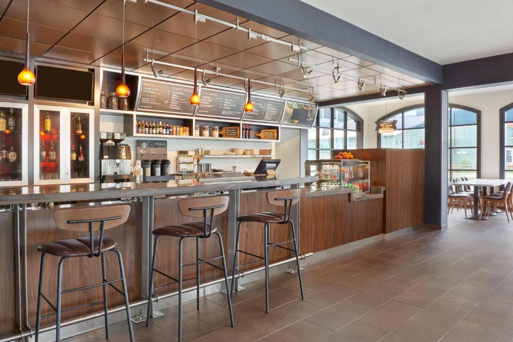 a bar in a restaurant with bar stools at Courtyard by Marriott Waterloo St. Jacobs in Waterloo