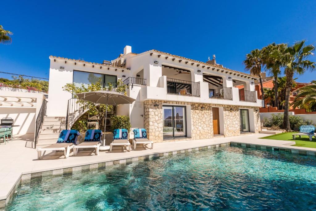 a villa with a swimming pool and a house at Casa Buena Vista in Teulada