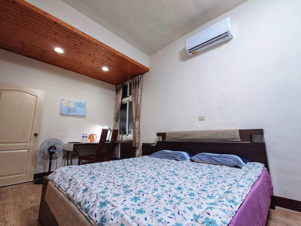 a bedroom with a bed and a desk and a window at Alley B&B in Magong